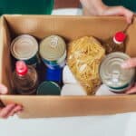 Volunteer with box of food for poor. Donation concept.